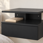 Détail de la niche ouverte du chevet noir avec un livre.