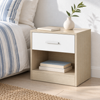 Chevet beige et blanc avec un vase dans une chambre lumineuse.