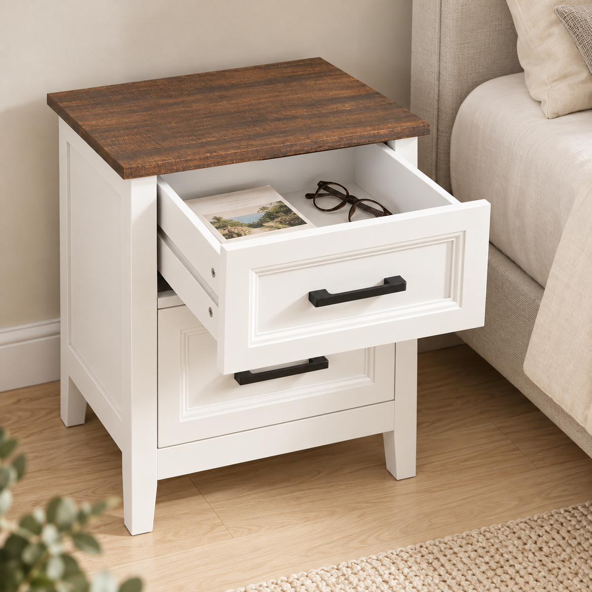 Table de chevet blanche avec tiroir supérieur ouvert et livre rangé