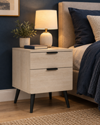 Table de chevet effet chêne avec lampe dans une chambre bleu nuit