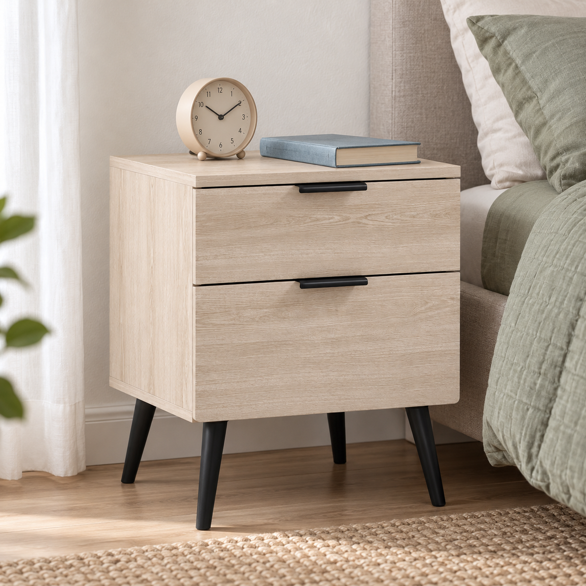 Table de chevet avec réveil dans une chambre vert sauge