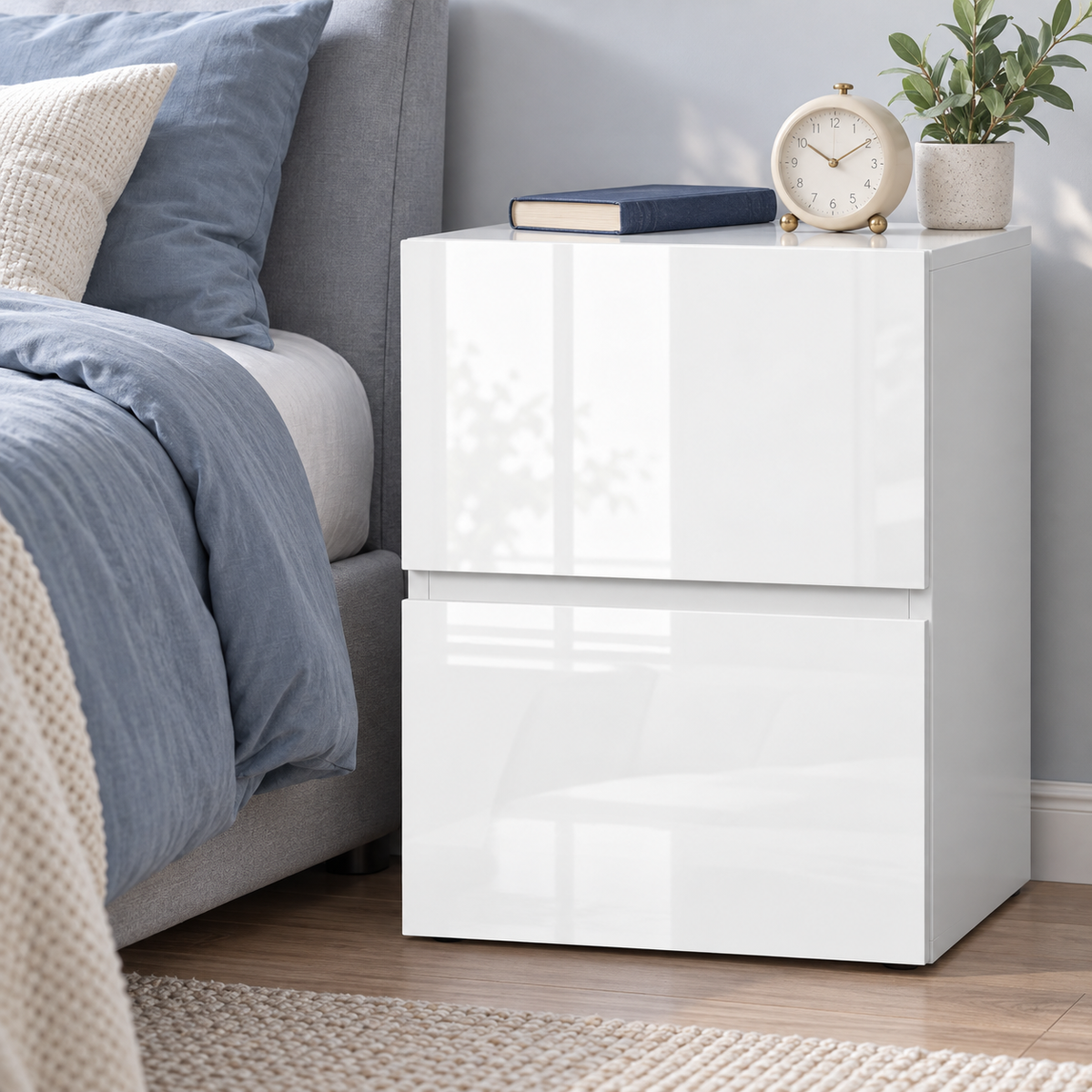 Table de chevet blanche avec réveil dans une chambre bleu doux