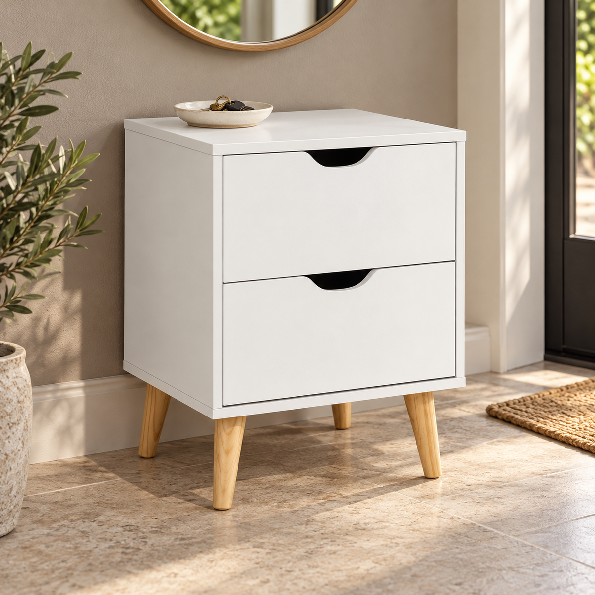Chevet blanc disposé dans une entrée avec vide-poche.