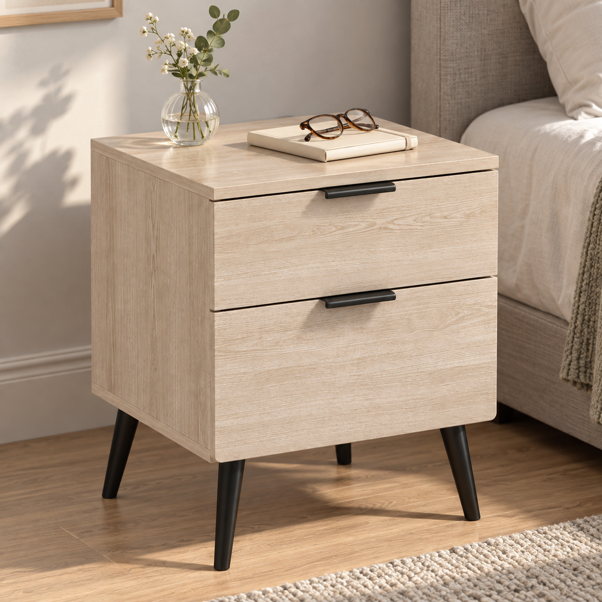 Table de chevet vue en plongée avec carnet et lunettes sur le plateau