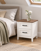 Table de chevet blanche avec vase de fleurs dans une chambre mansardée